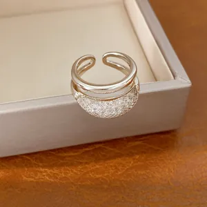 Detalle de un anillo abierto de doble capa con diseño de malla de circonitas.