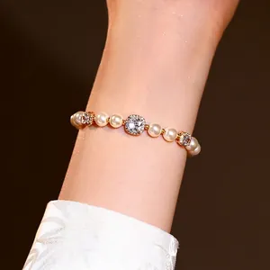Vue détaillée d'un bracelet de perles plaqué or avec zircons cubiques sur le poignet