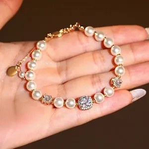 Élégant bracelet plaqué or avec perles blanches et zircons étincelants de forme carrée