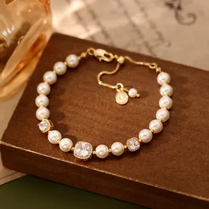 Vue détaillée d'un élégant bracelet plaqué or avec zircon carré et perles blanches