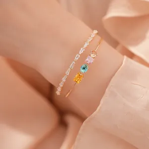 Detail eines 18 Karat vergoldeten Armreifs mit bunten Edelsteinen und Zirkonia