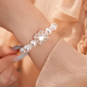 Elegantes Perlenarmband mit quadratischem Zirkonia-Blumendetail an einem Handgelenk