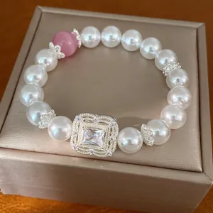 Elegantes weißes Perlenarmband mit quadratischem Zirkonia-Blumenanhänger und rosa Akzentperle