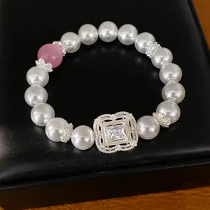 Detailansicht eines eleganten Perlenarmbands mit Zirkonia-Blume und rosa Perle.