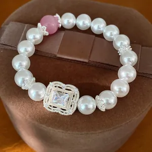 Nahaufnahme des eleganten quadratischen Zirkon-Blumen-Mittelstücks an einem Perlenarmband