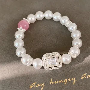 Detailansicht des eleganten quadratischen Zirkonia-Blumenelements auf dem Perlenarmband.