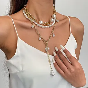 Detail van gelaagde vintage parelkettingset met gouden ketting en OT-sluiting