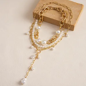Detail van retro gelaagde ketting met witte parels, gouden kettingen en OT-sluiting