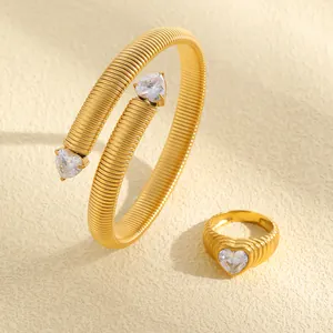 Detailansicht eines vintage gerippten Goldschmuck-Sets mit Armreif, Ring und Herz-Zirkonia
