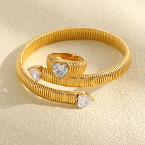 Detailansicht von Ring mit herzförmigem Zirkon und vergoldetem Armband aus Edelstahl
