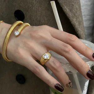 Detail von Vintage-Goldarmband und Ring-Set mit herzförmigem Zirkon an der Hand.