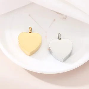 Minimalist gold and silver polished stainless steel heart pendants on an elegant white plate