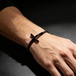Minimalistisches schwarzes gebogenes Kreuzarmband aus Edelstahl an einem Handgelenk