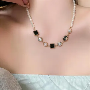 Detailweergave van een Franse luxe parelketting met zwarte vierkante stenen