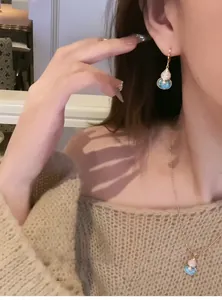 Close-up of turquoise gourd pendant necklace and earrings on model