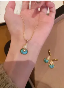 Detail of an 18k gold-plated turquoise gourd pendant necklace with sparkling zircons