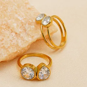 Primer plano de anillos de acero inoxidable chapados en oro de 14k con circonitas redondas