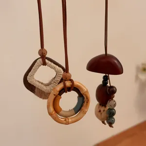 Handgemaakte kettingen met houten hangers, notendoppen en bamboe details.