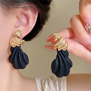 Pendientes modernos e irregulares retorcidos con diseño de pétalo negro mate y oro