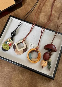 Gedetailleerde weergave van vier etnische boho-kettingen met houten en notenhouten hangers