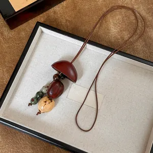 Detailweergave van handgemaakte houten notendop hanger ketting met kralen