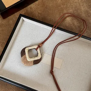 Gedetailleerd zicht op een handgemaakte houten notendop hanger met geweven vezel