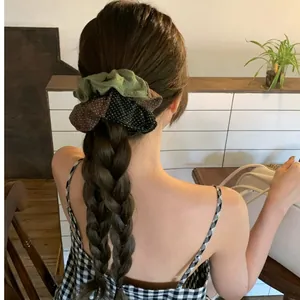 Détail d'un chouchou plissé à pois multicolores sur une coiffure tressée chic