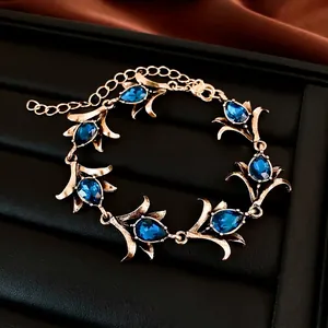 Vintage gouden bloemenarmband met elegante blauwe druppelvormige strass en verstelbare ketting