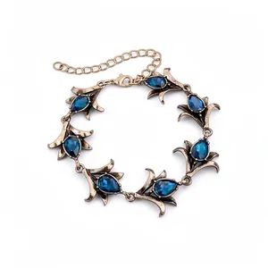 Elegante vintage bloemenarmband met blauwe kristallen in druppelvorm en antieke goudfinish