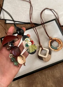 Detailweergave van handgemaakte etnische houten en schelpen kettingen met kwastjes