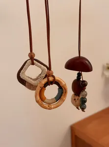 Detailopname van handgemaakte artistieke houten en notendop hangers met weefsel