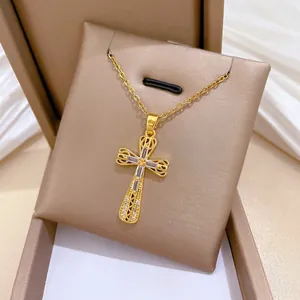 Dettaglio collana con pendente a croce in oro traforato con zirconi brillanti.