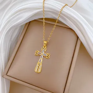 Primo piano della collana a croce in acciaio titanio dorato con pietre di zircone.