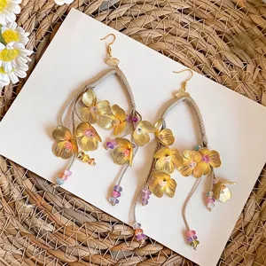 Elegantes pendientes bohemios de flores doradas con borlas y cuentas de colores