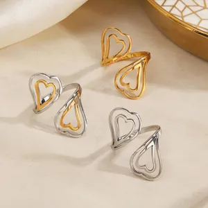 Bagues ajustables en acier titane avec double cœur entrelacé évidé en or et argent.