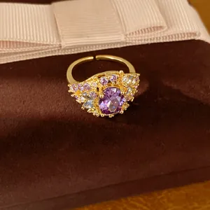 Detailansicht eines 18 Karat vergoldeten offenen Rings mit violettem ovalem Zirkonia-Stein
