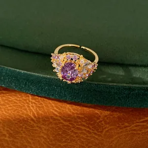 Detailaufnahme eines 18 Karat vergoldeten lila Zirkonia-Rings auf grünem Samt