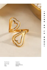 Gros plan élégant d'une bague ouverte double cœur en acier inoxydable au fini doré