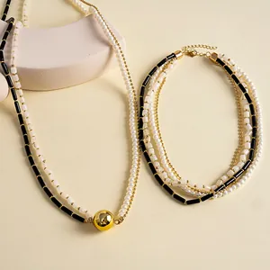 Gros plan de colliers multi-rangs en perles rétro et acrylique avec pendentif boule dorée