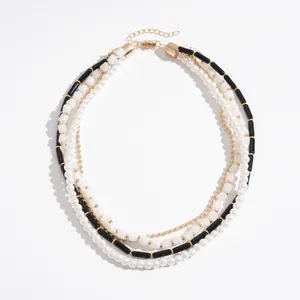 Collier multicouche vintage avec perles et tubes en acrylique sur fond blanc