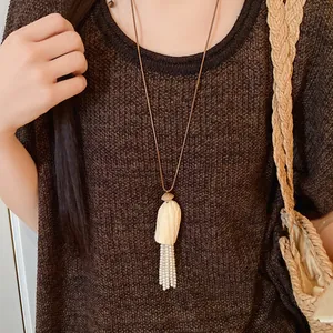 Vue détaillée d'un pendentif en bois avec des glands de perles sur un cordon en cuir