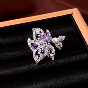 Elegante anillo chapado en oro de 18k con alas de mariposa, circón púrpura y perla.