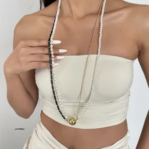 Détail d'un long collier de perles vintage superposées en acrylique sur un modèle