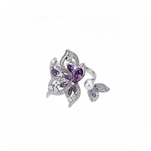 Elegante anillo ala de mariposa plateado con circonitas moradas y una perla