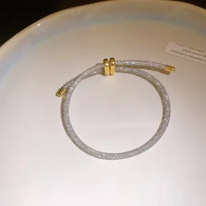 Detail van zirkonia armband met zilveren gaas en verstelbare gouden schuifsluiting
