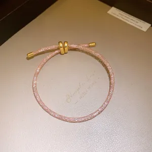 Detail van roze zirkoon glinsterende armband met gouden verstelbare accenten