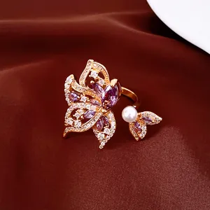 Detalle de anillo de ala de mariposa chapado en oro de 18k con circonitas y perla