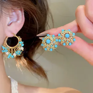 Vue détaillée de boucles d'oreilles vintage dorées à l'or 18 carats avec turquoise.