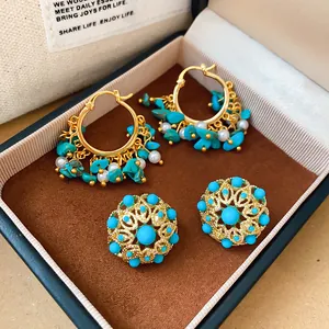 Vue détaillée de boucles d'oreilles vintage dorées avec turquoise et perles