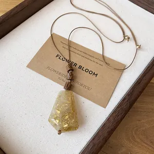 Detalle de collar de cordón de cuero con colgante de resina artístico y pan de oro
